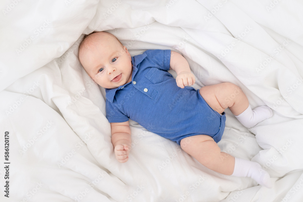 baby boy in the crib, happy newborn wakes up in the morning or goes to bed baby boy in the crib, happy newborn wakes up in the morning or goes to bed