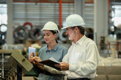 woman engineer assistant secretary in helmet inspection check control heavy machine construction installation in industrial factory with boss manager. Boss and partnership check maintenance factory