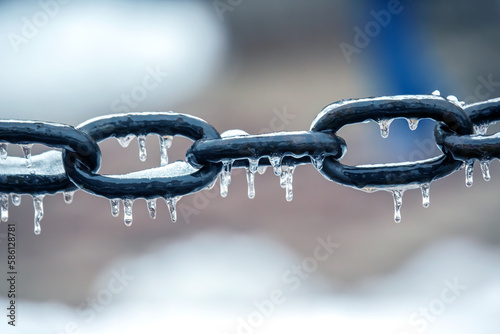 icicles on a frozen metal chain. winter weather season. street interior details