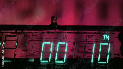 Close-up view of 15 seconds digital clock countdown timer of glowing green digits on pink background.
