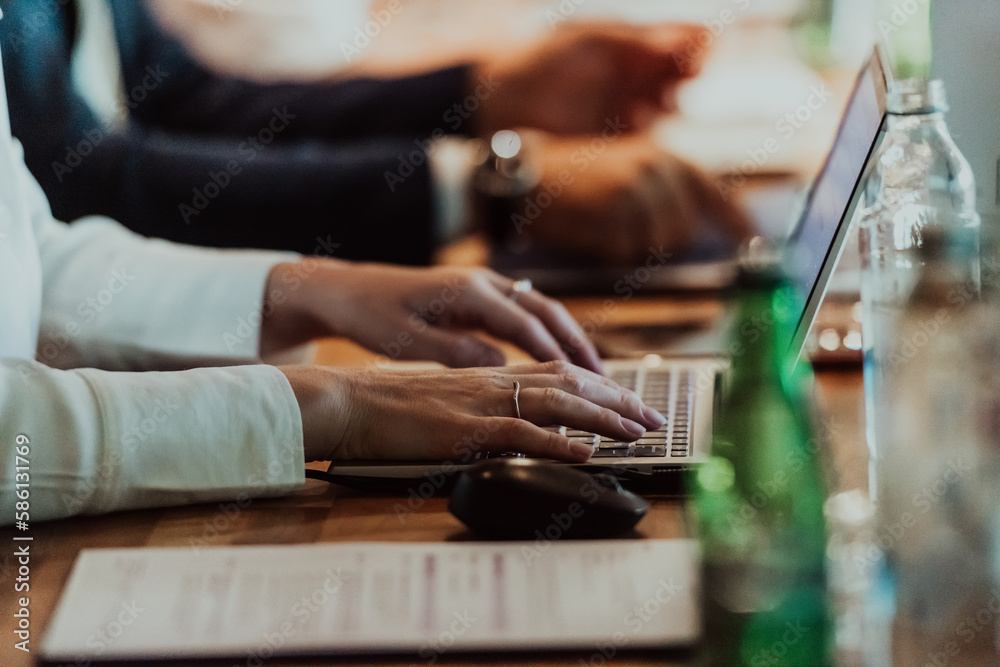 Close up photo of a woman's hand typing on a laptop at a seminar Close up photo of a woman's hand typing on a laptop at a seminar