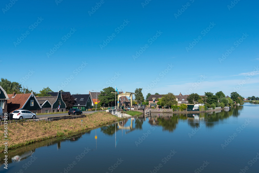 Dorfbild mit Grachtenbrücke am Drechterlandsdijk in Ursem. Provinz Nordholland in den Niederlanden