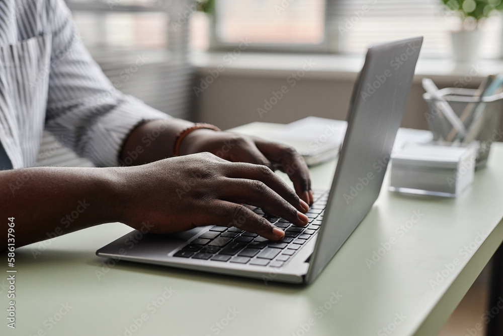 Close up of unrecognizable black man working online , focus on male hands typing at laptop keyboard Close up of unrecognizable black man working online , focus on male hands typing at laptop keyboard