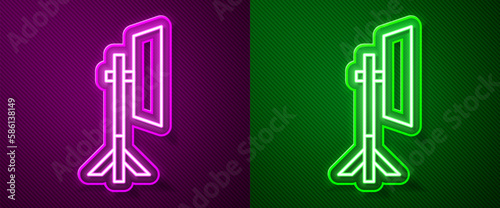 Glowing neon line Studio light bulb in softbox icon isolated on purple and green background. Shadow reflection design. Vector