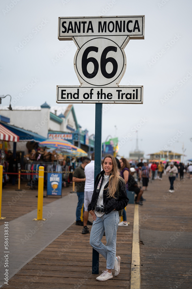 Portrait of a blonde young girl at the Santa Monica Pier celebrating the end of Route 66