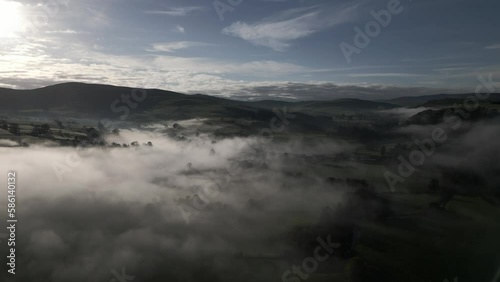 Incredible British rural landscape aerial scene with low lying fog over the countryside