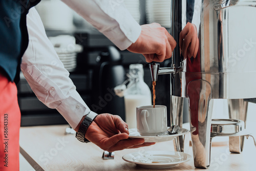 The waiter preparing coffee for hotel guests. Close up photo of service in modern hotels