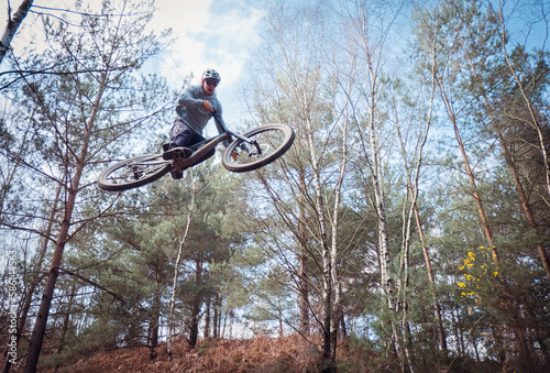 Mountain biker jumping in the forest