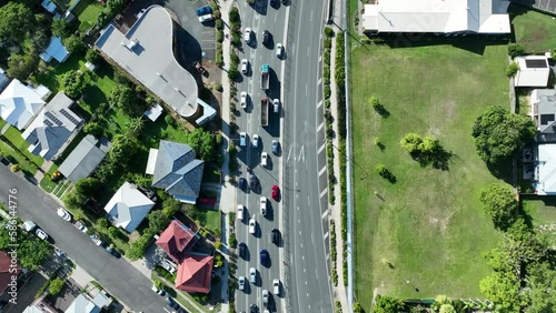 Drone top down shot of heavy traffic on Gympie Road, Kedron, Brisbane. Camera tracking the traffic flying forwards, while looking straight down. Shot in afternoon light with blue skies. photo