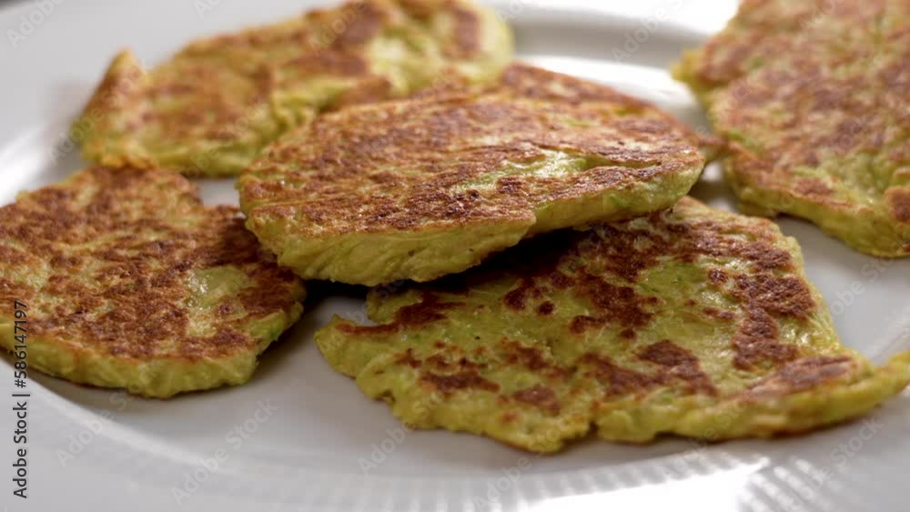 Fresh vegetable dietary zucchini fritters on a ceramic dish closeup Fresh vegetable dietary zucchini fritters on a ceramic dish closeup