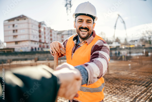 A site worker is shaking hands with contractor on site.