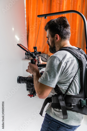 The cameraman in the studio using a professional camera with a stabilizer © .shock