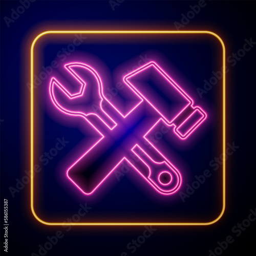 Glowing neon Crossed hammer and wrench spanner icon isolated on black background. Hardware tools. Vector