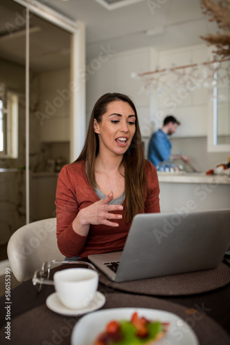 Young female manager having a video call on her laptop, working from home.