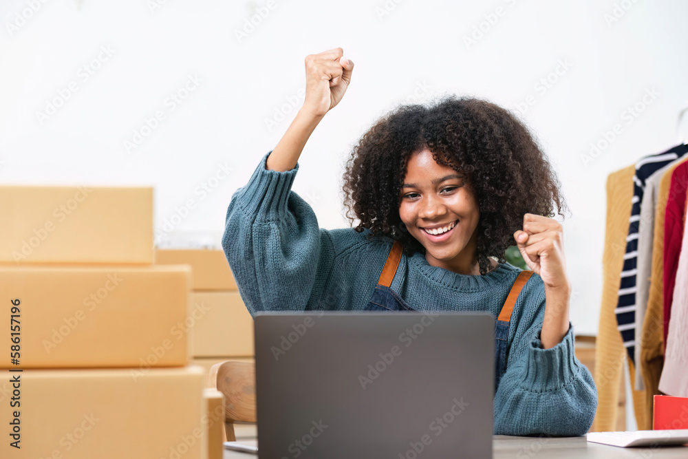 Happy young Asian woman entrepreneur, Smile for sales success after checking order from online shopping store in a smartphone at home office, Concept of merchant business online and eCommerce Happy young Asian woman entrepreneur, Smile for sales success after checking order from online shopping store in a smartphone at home office, Concept of merchant business online and eCommerce