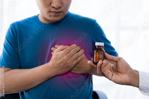 Chest pain, young asian man having a heart attack, man suffering from sadness health concept heart attack problem Warning signs of a serious illness. Health care and heart concept