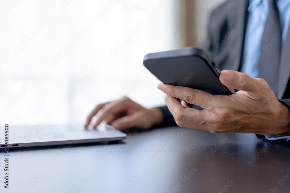 Businessman using smartphone to send text messages in the office. Businessman using smartphone to send text messages in the office.