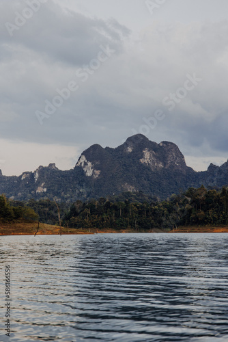 Traditional wooden long tail boat cruise on Cheow Lan Lake among rock formations in Khao Sok National Park, Surat Thani Province in Thailand, Southeast Asia