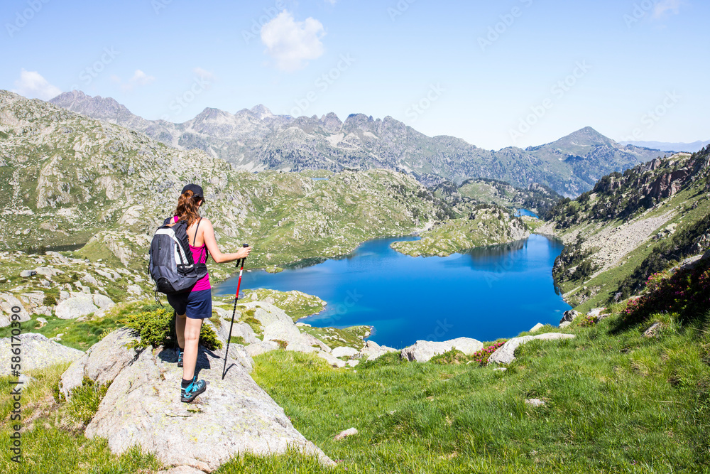 Naklejka premium Young hiker girl summit to Ratera Peak in Aiguestortes and Sant Maurici National Park, Spain