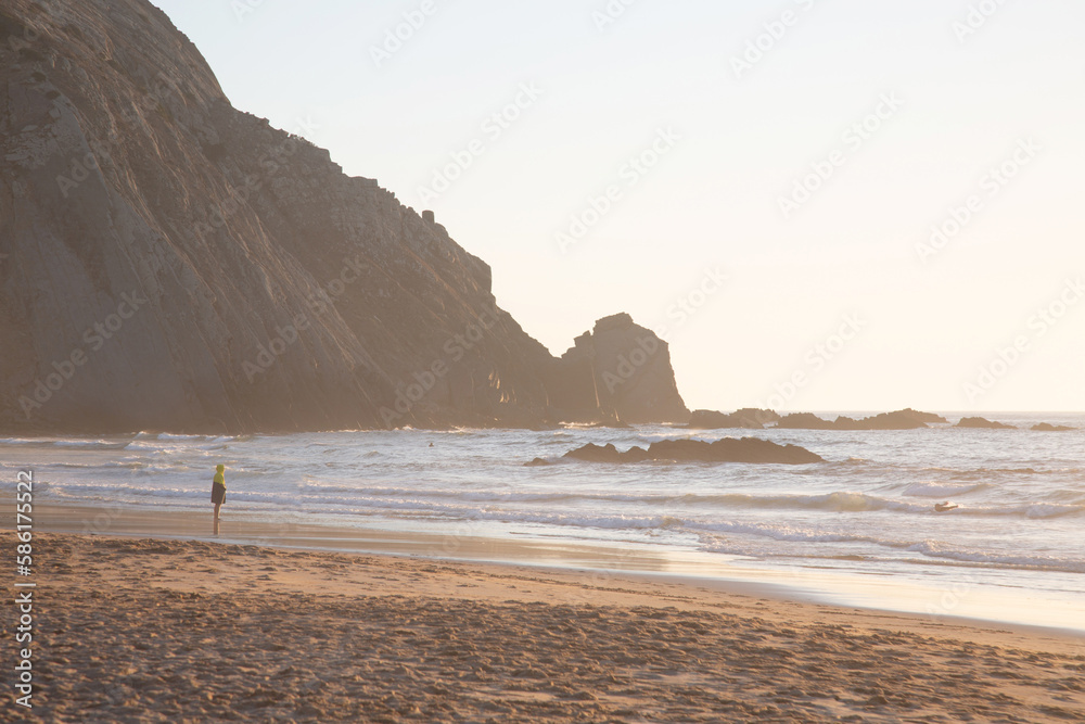 Figure with Sea, Cliffs and Rocks With Mist at Odeceixe Beach; Algarve; Portugal