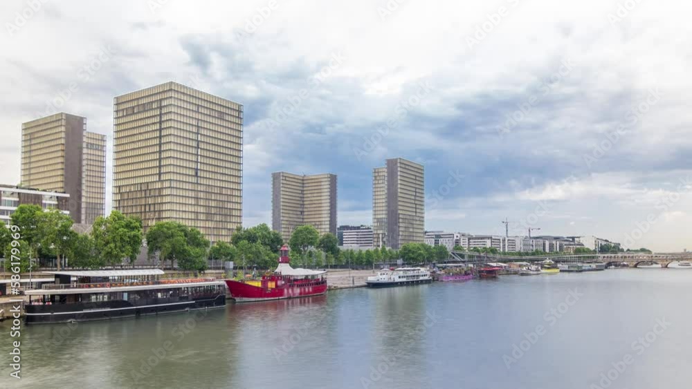 National Library of France timelapse hyperlapse, whose four buildings in the form of open books surround a wooded area. Aerial view from Bridge of Tolbiac with reflection on Seine river. Paris, France National Library of France timelapse hyperlapse, whose four buildings in the form of open books surround a wooded area. Aerial view from Bridge of Tolbiac with reflection on Seine river. Paris, France