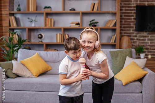 Two children sing song. Concept is childhood, vocal, music, singing. Microphone and headphones. photo