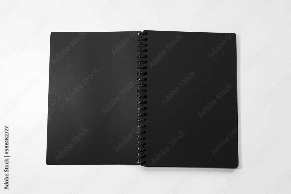 Close-up of black opened notebook on white background. Close-up of black opened notebook on white background.