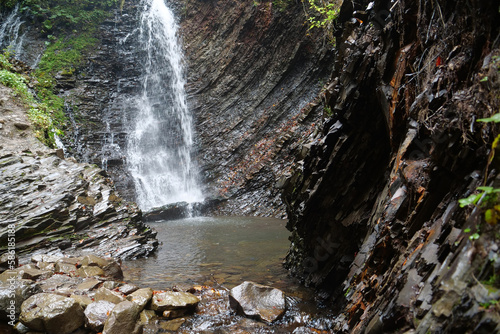 Little waterfall and geological mountain folds in the mountains