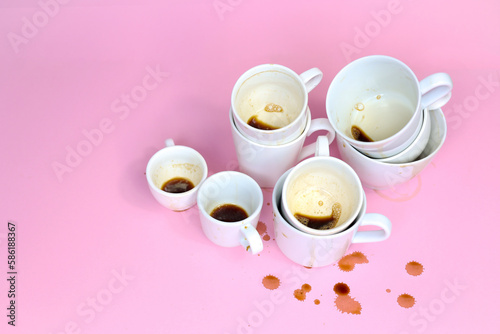 Stack of Dirty cups of coffee isolated on pink background. Coffee culture concept. 