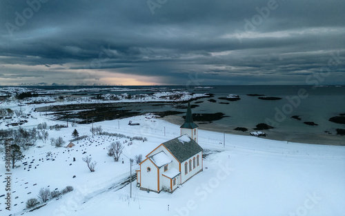 The drone shot allows for a unique perspective of the church, capturing its grandeur and beauty from above. Architectural photography, winter landscapes, or travel. Valberg Church, Lofoten Norway 