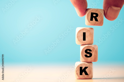 Hand putting risk wording print screen on wooden block cube for financial banking risk analysis and management ,Low risk low return concept. photo