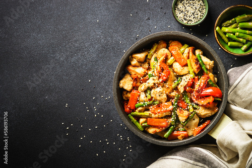 Fotografia Chicken stir fry with vegetables at stone background