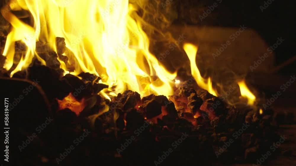 Brennendes Feuer in der Esse. Nahaufnahme von Flammen und Schmiedegut in Zeitlupe. Brennendes Feuer in der Esse. Nahaufnahme von Flammen und Schmiedegut in Zeitlupe.