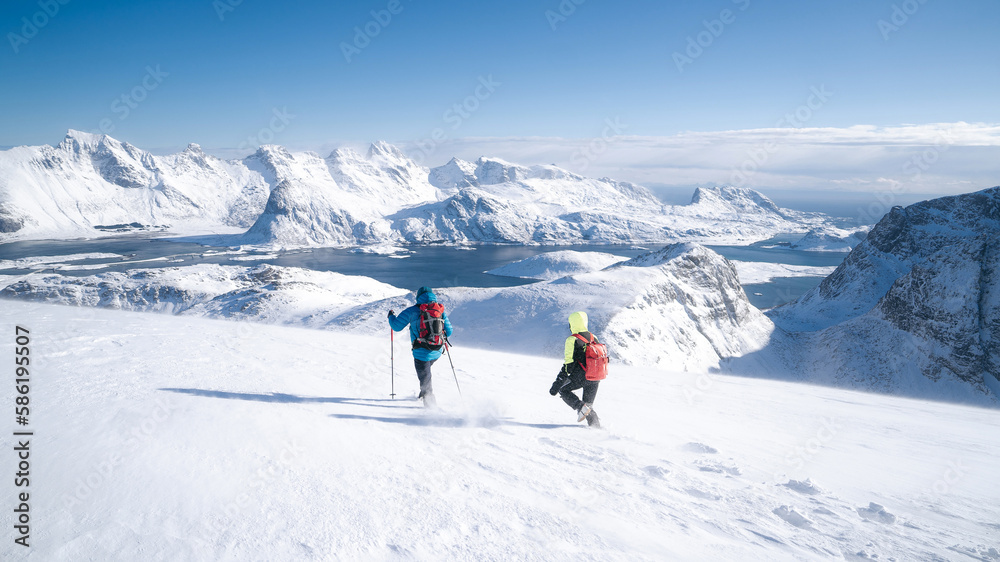 Process of hiking in Northern Norway, Lofoten Islands, Nordland, on the way to Ryten mountain and Kvalvika beach, with a groups of hikers, and mountains around, sunny winter day