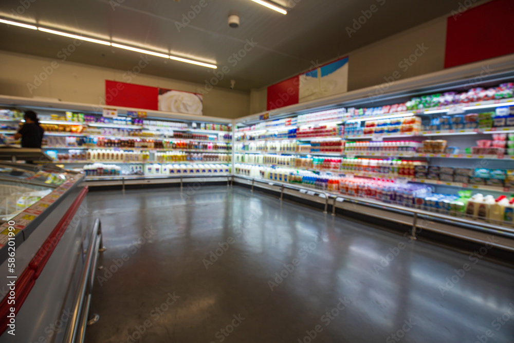 Defocused blur buying milk put on shelf in supermarket