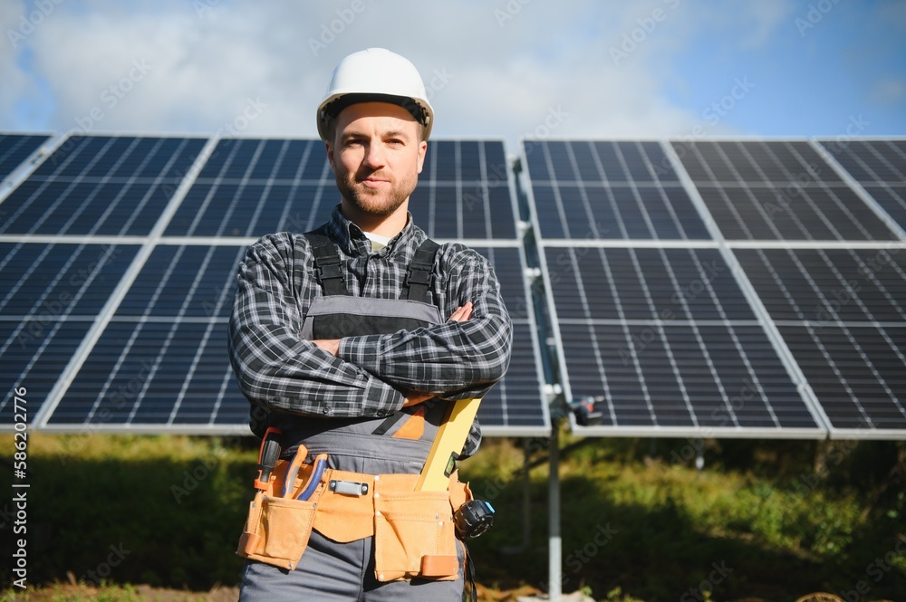 A handyman standing on the rooftop with solar panels and smiling at the camera. A handyman standing on the rooftop with solar panels and smiling at the camera.