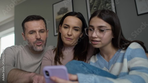 Caucasian family having fun while browsing mobile phone together. Shot with RED helium camera in 8K.  