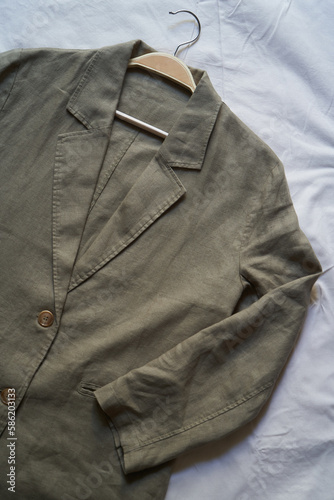 Gray linen jacket hanging on clothes hanger