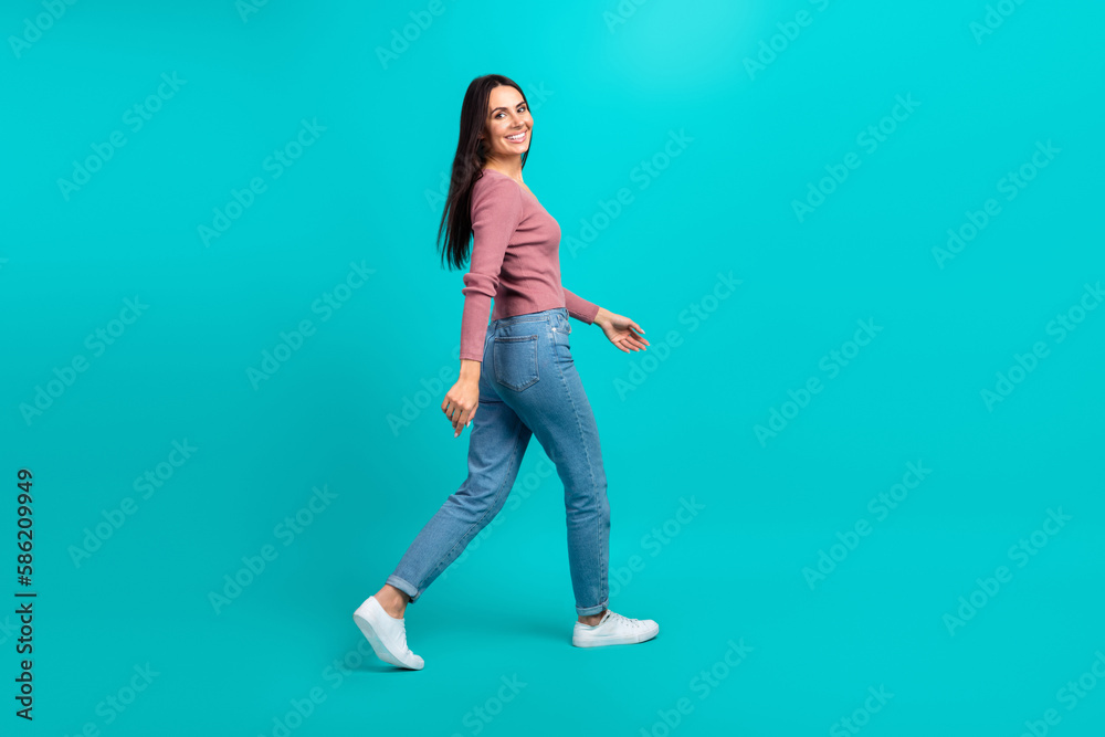 Full body profile photo of cheerful lovely lady walking empty space good mood isolated on teal color background