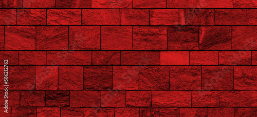 Wide old stone wall texture with red lighting. Panoramic stone block wall background with red light for banner design