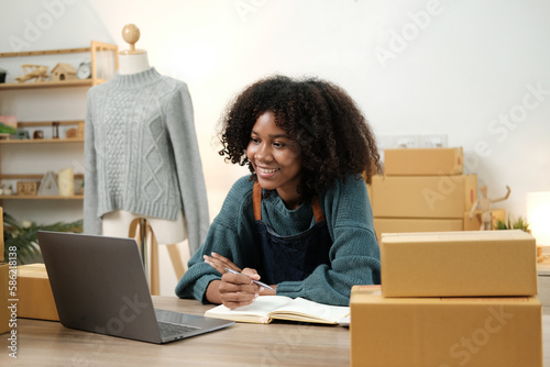 American African entrepreneur smile and checking online order. Successful SME entrepreneur concept