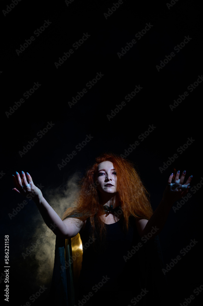 An evil red-haired witch holds fire in her hands.