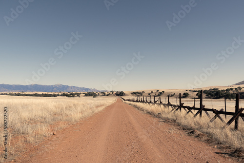 A lonely dirt road through the grasslands along the border between the United States and Mexico in Arizona.