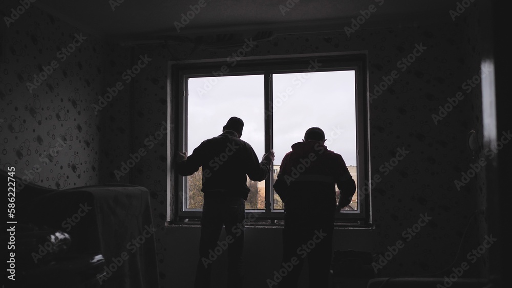Silhouettes of workers installing new plastic windows.