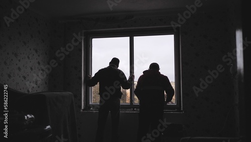 Silhouettes of workers installing new plastic windows.