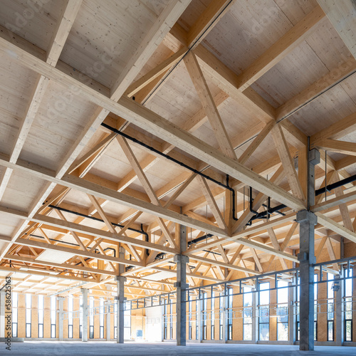 modern industrial hall with timber trusses and prefabricated concrete columns with many glass facade elements