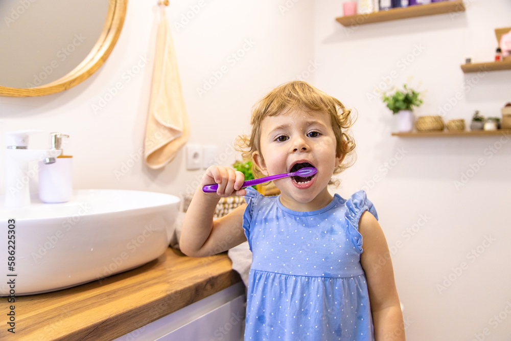 The child brushes his teeth in the bathroom. Selective focus. The child brushes his teeth in the bathroom. Selective focus.