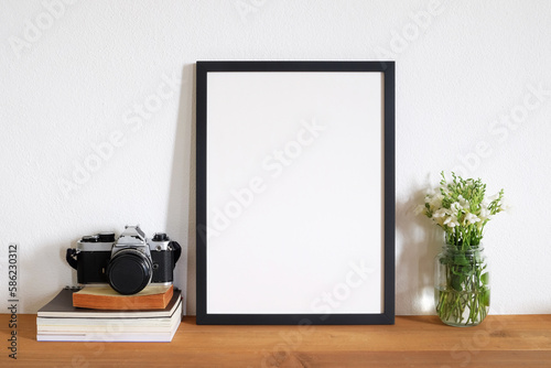 blank photo frame with film camera on table