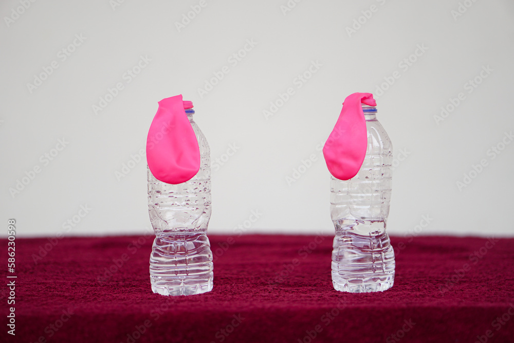 Fotografie Pink flat balloons on top of transparent test bottles