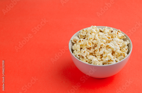 Popcorns in a bowl over red background with copy space
